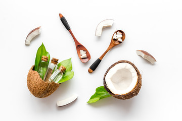 Coconut cosmetics. Organic oil in small bottles on white background top-down