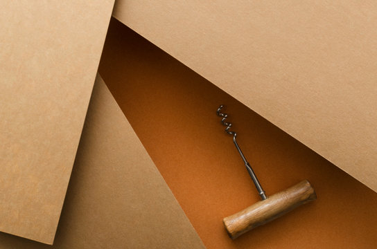 Top view of corkscrew with wooden handle on thw crast orange nad brown background.Empty space for design.Wine tasting