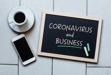 Coronavirus and Business text written on blackboard.