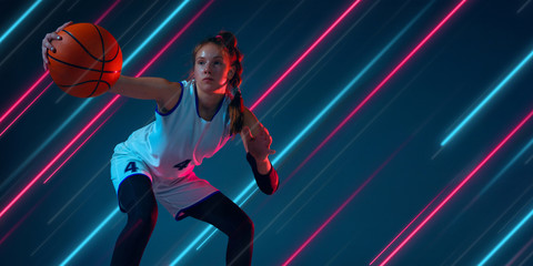 Creative sport and neon lines on dark background, flyer, proposal. Female basketball player training in action and motion. Concept of hobby, healthy lifestyle, youth, action, movement, modern style.