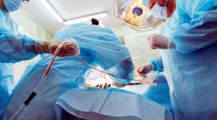 cosmetic liposuction surgery in actual operating room setting showing surgeon hands and cannula