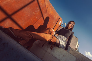 Fototapeta na wymiar stylish girl model posing sitting on the steps of the building