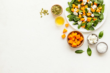 Cooking salad with pumpkin and basil. Ingredients on white background top-down copy space