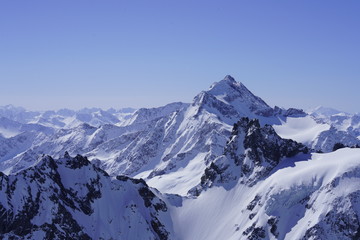 Fototapeta na wymiar Snow-covered mountains and blue sky