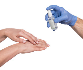 Doctor in protective blue glove treating the patient’s hands with antiseptic