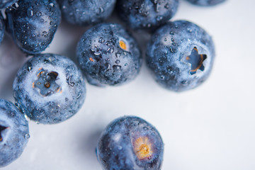 Water drops on ripe sweet blueberry on white background
