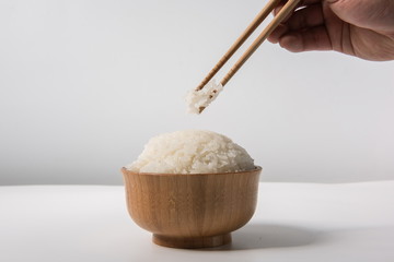 Cooked rice, rice in a wooden bowl, isolated against a white background,