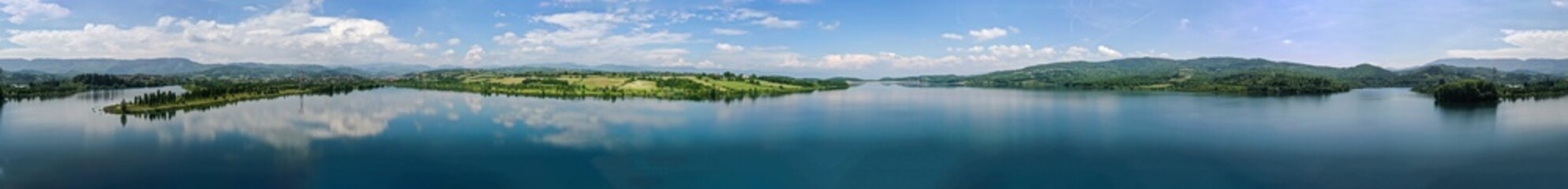 Fototapeta na wymiar Beautiful lake and mountain scenery; blue sky and white clouds reflecting on the water