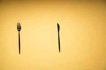 The fork and knife are on a yellow background