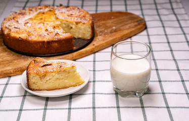 cut off part homemade cake and glass milk wooden