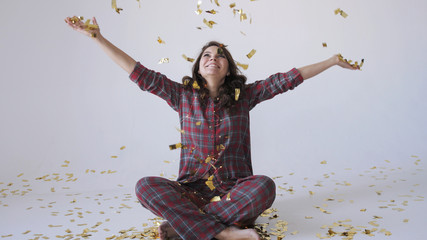 Beautiful woman throwing gold confetti.