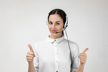 Beautiful smiling woman consultant of call center in headphones on gray background. female customer...