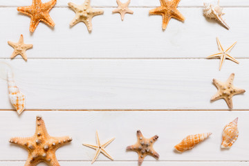 Fototapeta na wymiar Flat lay of various seashell and starfish on white wooden table, top view. Copy space background, summer concept