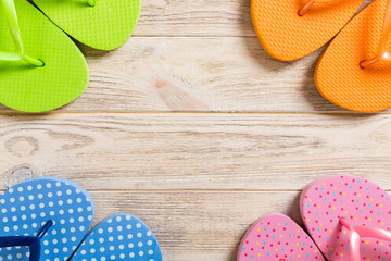 a lot of flip flop colored sandals, summer vacation on wooden background, copy space top view