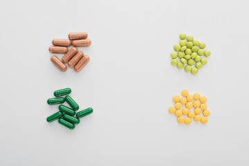 Top view of pills and capsules on white background