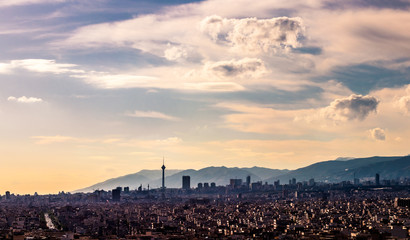 Obraz premium Tehran skyline in a beautiful cloudy day with golden hour light Tehran-Iran cityscape with Milad tower in photo and white clouds and lovely blue sky