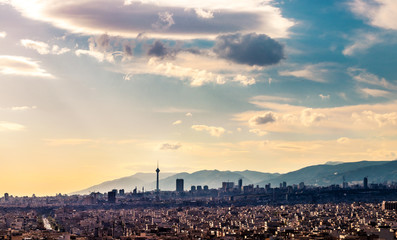 Tehran skyline in a beautiful cloudy day with golden hour light Tehran-Iran cityscape with Milad tower in photo and white clouds and lovely blue sky
