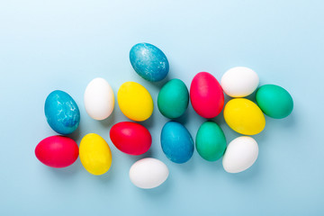 Easter composition. Multicolored easter eggs on blue background. Copy space