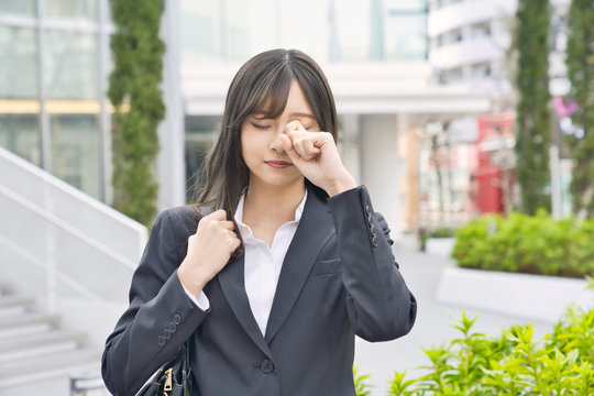 目をこする女性