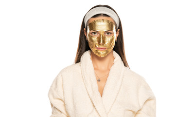 young woman posing with golden mask on her face