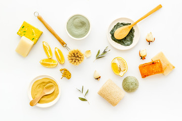 Face, body skin care homemade ingredients - cosmetic clay, brushes, homemade soap, scrub, herbs on a white background. Top view