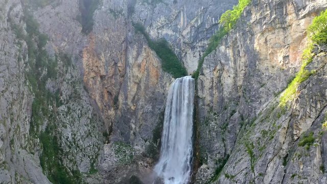 Jib up shot of the impressive Boka Waterfall flowing along a limestone wall in western Slovenia