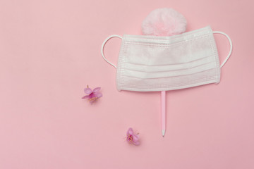 white health protective mask from corona virus or covid-19 disease with natural pink flower and fluffy cute pen