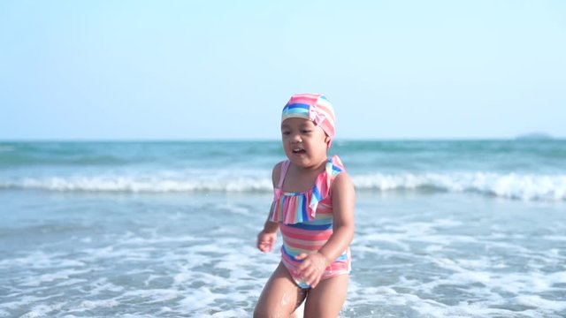 Happy little girl joyful on the beach and running