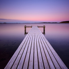 Wooden frosty jetty leading into the sea, Sweden.