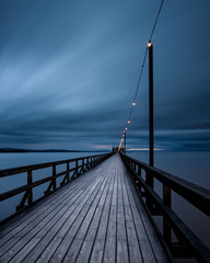Wooden boardwalk under overcast sky, Sweden.
