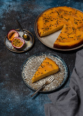 Summer tropical dessert. Fresh baked mango upside down cake with passion fruit and a piece cut off on a plate. Selective focus.