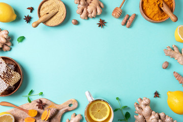 Organic ingredients for turmeric hot tea on blue background. Antiviral beverage. Healthy ayurvedic drink with lemon, ginger, cinnamon, turmeric. Immune boosting remedy