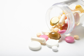 A lot of different pills in a jar on a white background. Close-up. The medicine. Medication