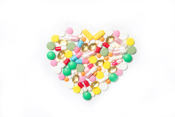 Heart made of multi-colored pills on a white background. Health and medicine concept