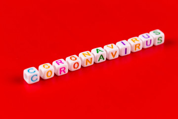 Pandemic and virus concept - Coronavirus word made of colourful blocks. Coronavirus text on red background. Coronavirus concept top view.