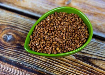 Dry buckwheat in ceramic bowl.