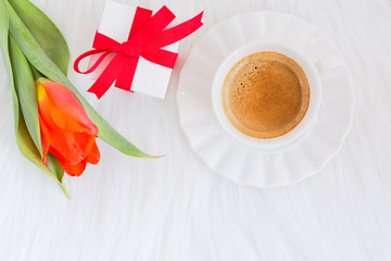 Romantic holiday concept: Red ribbon gift box and aromatic black coffee  on white background. Copy space.