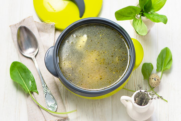 sorrel spinach soup with vegetables on chicken stock in a pan