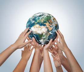 Many children hands holding planet earth isolated on blue background with copy space - obrazy, fototapety, plakaty