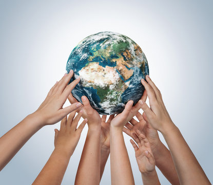 Many children hands holding planet earth isolated on blue background with copy space