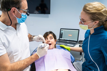 Teeth checkup at dentist's office. Dentist examining little girl's teeth in clinic