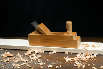 old wooden planer with wood shavings on a wooden surface