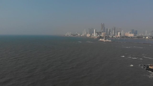 Rotating drone shot around haji ali dargah and Mumbai city from the sea