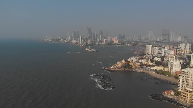 Falling drone shot of the Mumbai coastline on a sunny day
