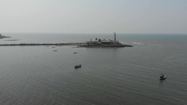 A shot moving back from a white mosque in the middle of the sea