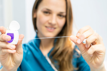 Dentist woman showing dental floss