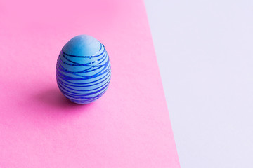 Blue Easter egg on a pink background.
