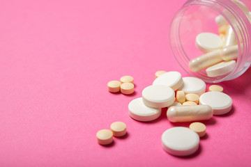 Jar with pills on a pink background. Place for text.