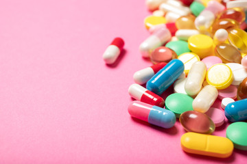 Pills and capsules on a pink background.Concept of medicine and health.