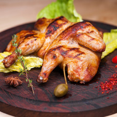 Roast chicken and leaf lettuce on a wooden board